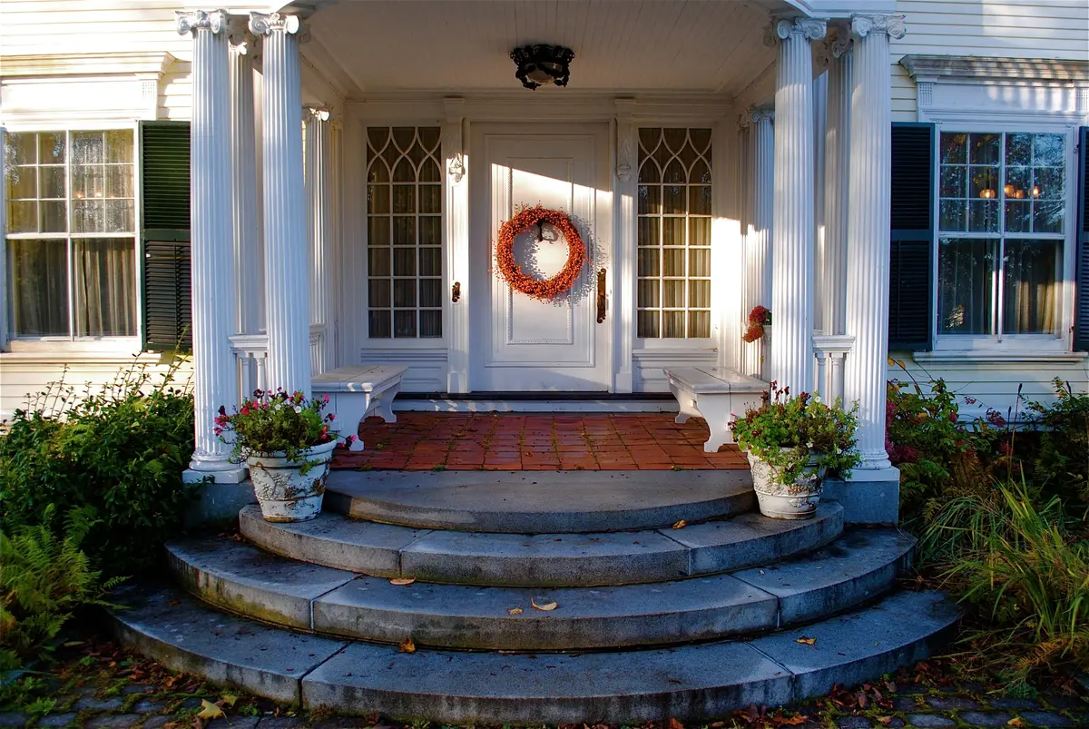 Architectural inspiration: white columned entrance with a wreath and curved stone steps in Bath, Maine